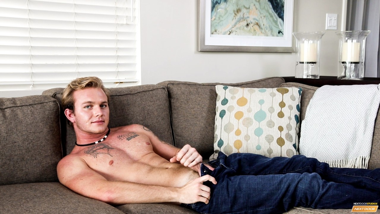 Cute tattooed jock Rex Tanner strips on the sofa and chokes the monkey  